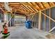Interior of garage with exposed wood beams and concrete floor, featuring blue trash cans at 6741 Evanston Ave, Indianapolis, IN 46220