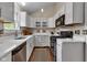 Contemporary kitchen featuring white cabinetry, a gas range, and modern lighting fixtures at 6741 Evanston Ave, Indianapolis, IN 46220
