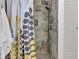 A tiled shower with a decorative shower curtain, stone tile, and a built-in niche at 6741 Evanston Ave, Indianapolis, IN 46220