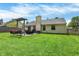 This backyard includes a patio with a dining table, fire pit and swing for outdoor enjoyment and entertaining at 6838 Cherry Laurel Ln, Fishers, IN 46038