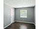 A minimalist bedroom featuring a large window, closet, and hardwood floors at 6838 Cherry Laurel Ln, Fishers, IN 46038