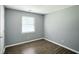 Bedroom featuring modern trim, sleek hardwood floors, and a sunlit window at 6838 Cherry Laurel Ln, Fishers, IN 46038