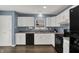 A bright kitchen featuring white cabinets, stainless steel appliances, and modern fixtures at 6838 Cherry Laurel Ln, Fishers, IN 46038