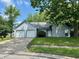 Charming home with a two-car garage, well-maintained lawn, and inviting curb appeal with mature trees at 7042 Colita More Ct, Indianapolis, IN 46254