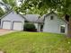 Charming home with a two-car garage, manicured lawn, and classic architectural design details at 7042 Colita More Ct, Indianapolis, IN 46254
