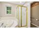 Bathroom featuring a tiled tub and a gold-framed shower stall at 829 Pioneer Woods Dr, Indianapolis, IN 46224