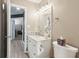 Bathroom features a white vanity with decorative mirror, updated lighting and fixtures, and a nearby toilet at 829 Pioneer Woods Dr, Indianapolis, IN 46224