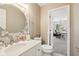 Bright bathroom with modern vanity, decorative mirror, nearby toilet, and a door that leads to another room at 829 Pioneer Woods Dr, Indianapolis, IN 46224