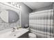 Modern bathroom features a gray vanity with a round mirror, gray walls and striped shower curtain at 829 Pioneer Woods Dr, Indianapolis, IN 46224