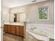 Bathroom featuring a double sink vanity and tiled tub at 829 Pioneer Woods Dr, Indianapolis, IN 46224