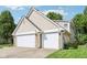 Exterior showcasing the home's vinyl siding, brick accents, and a convenient two-car garage, complemented by the well-maintained landscaping at 829 Pioneer Woods Dr, Indianapolis, IN 46224