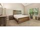 Main bedroom boasts modern wood furnishings, neutral walls and carpet, and large bright window at 829 Pioneer Woods Dr, Indianapolis, IN 46224