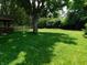 Large backyard features mature trees and lush green grass, perfect for outdoor activities at 8425 E 82Nd E St, Indianapolis, IN 46256