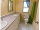 A full bathroom features a double sink vanity, toilet, and tub-shower combination with bright natural light at 8425 E 82Nd E St, Indianapolis, IN 46256