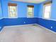 A blue bedroom with carpet and three windows with coverings and a ceiling fan at 8425 E 82Nd E St, Indianapolis, IN 46256