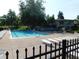 Community pool with lounge chairs and clean, clear water, surrounded by a secure fence at 8425 E 82Nd E St, Indianapolis, IN 46256