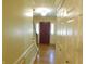 Bright hallway with hardwood floors, a staircase, and a view of the red front door at 8425 E 82Nd E St, Indianapolis, IN 46256