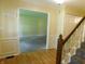 Hallway featuring hardwood floors, wainscoting, and an opening to a carpeted room with natural light at 8425 E 82Nd E St, Indianapolis, IN 46256