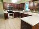 Updated kitchen features stainless steel appliances, dark wood cabinets, and tiled floor at 8425 E 82Nd E St, Indianapolis, IN 46256