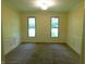 Spacious carpeted living room with natural light from two windows, and white wainscoting at 8425 E 82Nd E St, Indianapolis, IN 46256