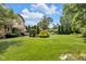 Spacious backyard featuring lush green grass, mature trees, and garden beds at 8525 Winding Ridge Rd, Indianapolis, IN 46217