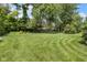 Large backyard featuring meticulously mowed grass and mature trees for ample outdoor space at 8525 Winding Ridge Rd, Indianapolis, IN 46217