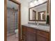 Well-lit bathroom featuring a vanity with granite countertop and a shower with glass block wall at 8525 Winding Ridge Rd, Indianapolis, IN 46217