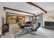 Spacious living room with stone fireplace, wooden beams and French doors with views of the backyard at 8525 Winding Ridge Rd, Indianapolis, IN 46217