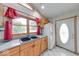 Kitchen sink near a window and white refrigerator with natural wood cabinets and grey countertops at 8635 S Providence Dr, Nineveh, IN 46164