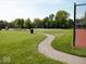 A large green space featuring a basketball court, picnic tables, and walking paths for outdoor activities at 9643 Cypress Way, Carmel, IN 46032