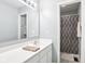 Well-lit bathroom with a clean aesthetic, featuring a large mirror, white vanity, and shower with neutral accents at 9643 Cypress Way, Carmel, IN 46032
