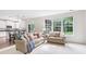 Bright and airy living room with hardwood floors, large windows, and comfortable seating is great for gatherings at 9643 Cypress Way, Carmel, IN 46032