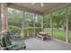 Cozy screened porch with comfortable seating and a lovely view of the landscaped yard at 9643 Cypress Way, Carmel, IN 46032
