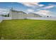 Spacious backyard with lush green grass, a white fence, and a seating area at 9775 Big Bend Dr, Indianapolis, IN 46234