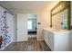 Bright bathroom features a shower with decorative curtain, stylish vanity, and a view into the bedroom at 9775 Big Bend Dr, Indianapolis, IN 46234