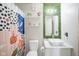 Colorful bathroom featuring floral shower curtain, modern fixtures, and greenery accent wall at 9775 Big Bend Dr, Indianapolis, IN 46234