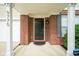 Charming brick entryway featuring a black front door with a SimpliSafe security system and a covered porch at 9775 Big Bend Dr, Indianapolis, IN 46234