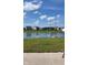 Serene backyard featuring a calm pond, green grass, and a partial view of a cement patio at 10218 Arctic Edge Dr, Indianapolis, IN 46259