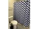 Bright bathroom showcasing a toilet next to a shower with a blue and white chevron shower curtain at 10218 Arctic Edge Dr, Indianapolis, IN 46259