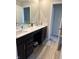 Bright bathroom features modern double sinks, dark cabinets, and wood-style flooring at 10218 Arctic Edge Dr, Indianapolis, IN 46259