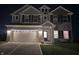 Exterior night shot of the home, illuminated by exterior lights, enhancing the home's curb appeal at 10218 Arctic Edge Dr, Indianapolis, IN 46259