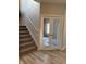 Staircase adjacent to glass paneled french doors and wood-look flooring at 10218 Arctic Edge Dr, Indianapolis, IN 46259