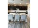 Well-lit kitchen with an island offering seating, dark cabinets, subway tile backsplash, and quartz countertops at 10218 Arctic Edge Dr, Indianapolis, IN 46259