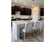 Bright kitchen island with white countertops, bar stool seating, sink, and dark cabinetry provides a great workspace at 10218 Arctic Edge Dr, Indianapolis, IN 46259