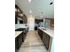 Modern kitchen boasting stainless steel appliances, white backsplash, dark cabinetry, light countertops, and wood floors at 10218 Arctic Edge Dr, Indianapolis, IN 46259