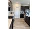 Modern kitchen has dark cabinetry, quartz countertops, gas stove, stainless appliances and wood grain vinyl flooring at 10218 Arctic Edge Dr, Indianapolis, IN 46259