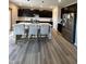Spacious kitchen with an island, dark cabinets, stainless steel appliances, and a wood-look floor for modern living at 10218 Arctic Edge Dr, Indianapolis, IN 46259
