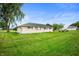 Backyard featuring large lawn with mature trees, with a partial view of home's exterior at 10500 S County Road 200 W, Muncie, IN 47302