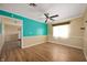 Bright living area featuring wood floors, a ceiling fan, and a vibrant accent wall at 10500 S County Road 200 W, Muncie, IN 47302