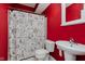 This bathroom features a unique black and white shower curtain and bright red walls at 11074 Galley Way, Fishers, IN 46040